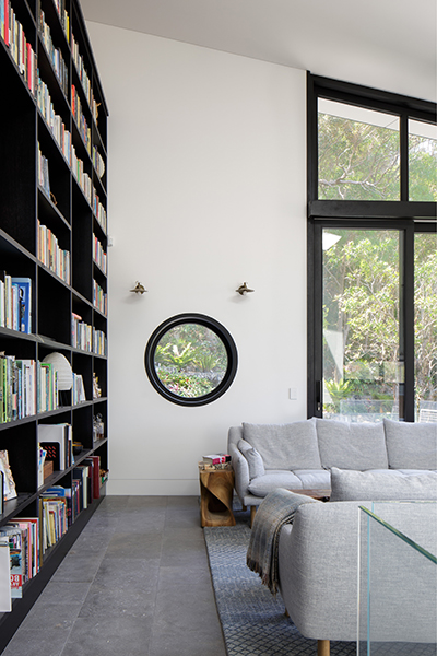 Living room with bookshelves, clerestory windows and a round windows. double glazed and bushfire safe
